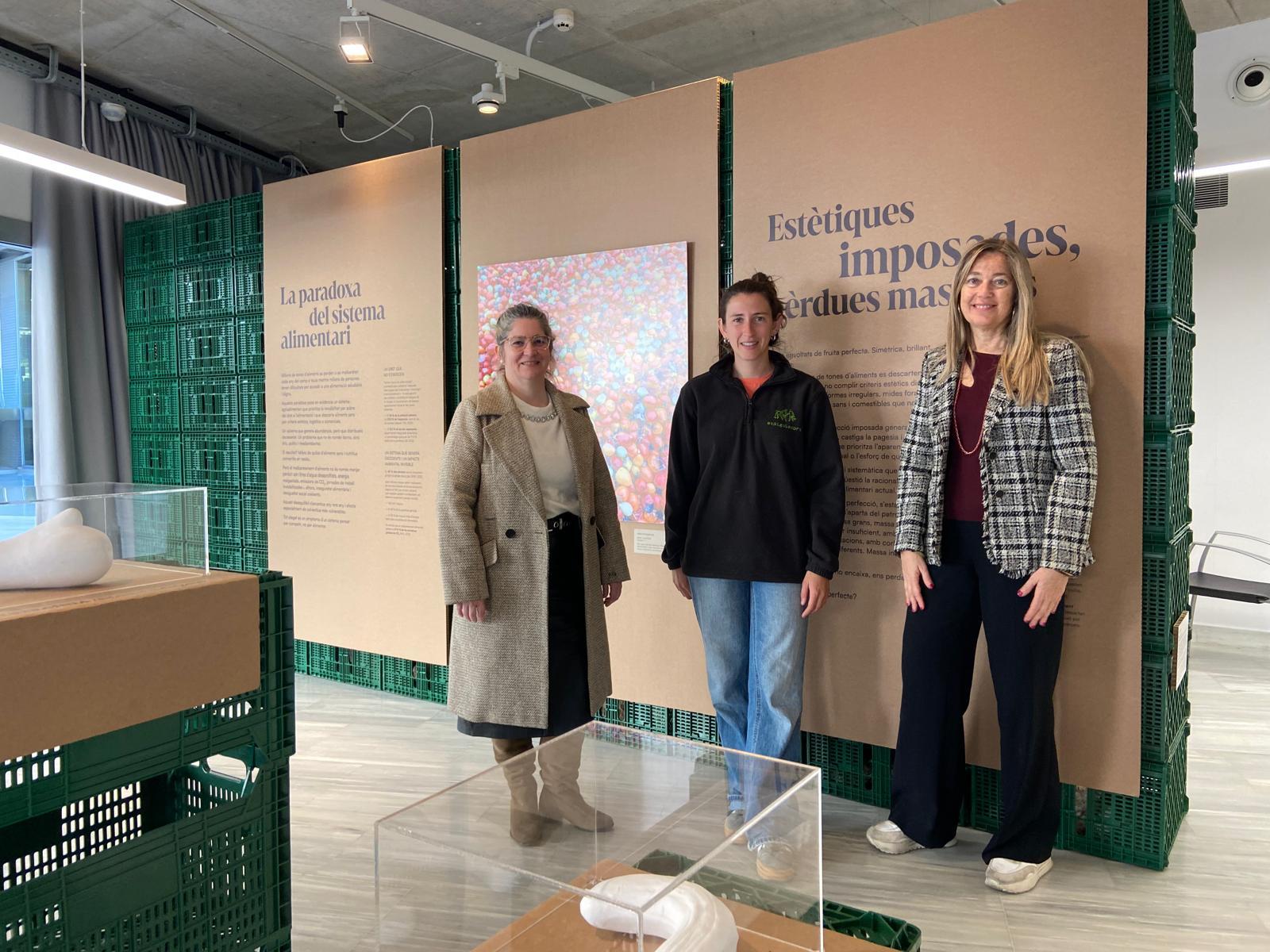 La vicepresidenta tercera de la Diputació de Girona i presidenta de Dipsalut, Maria Puig, amb la gerenta de l'Organisme, Sílvia Oliveras, i Cristina Cabot, responsable de la Fundació Espigoladors durant la visita a l'exposició "Espigolar per transformar"